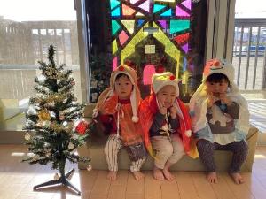 2歳児りす組がクリスマスツリーの前で写真を撮っている様子