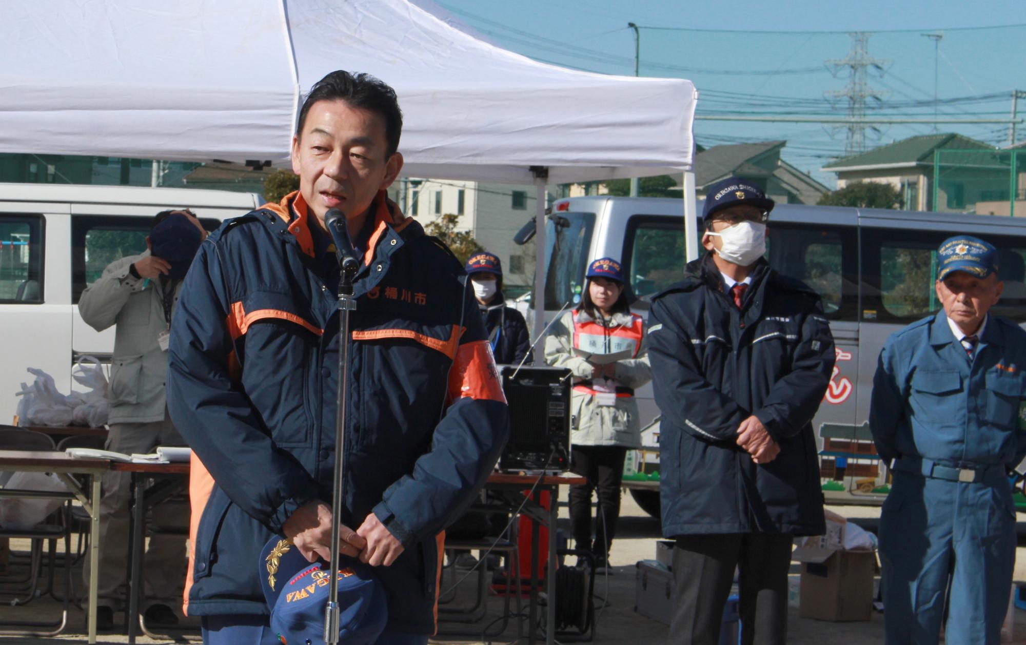 地域防災訓練での閉会挨拶の時の写真で、市長がマイクの前で挨拶をしている