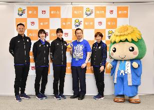 上尾メディックスの選手、監督と並んで写真を撮る小野市長