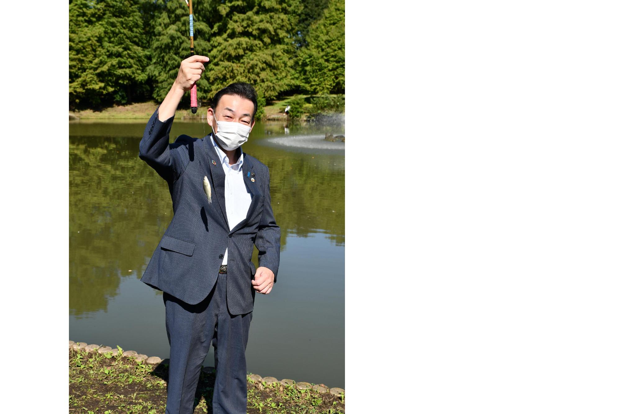 第4回初めての魚釣り体験の画像。第3回大会（令和3年）で、10センチのフナを釣り上げた小野桶川市長の様子が写っている。