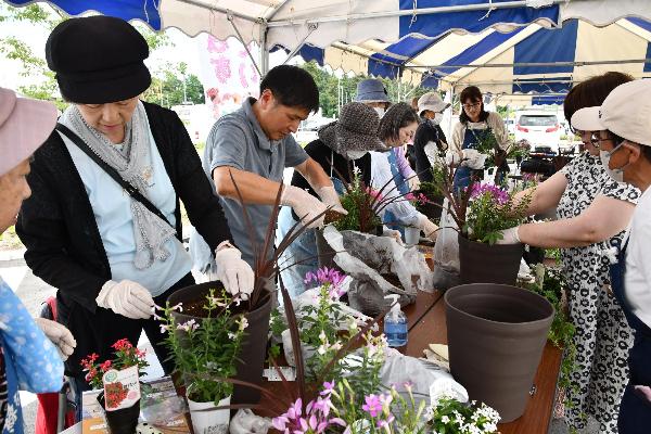 過去のガーデニング教室の画像。参加者が鉢に植え付けしている様子