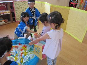 縁日遊びで金魚すくいをしている様子