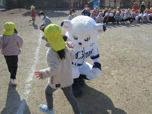 埼玉西武ライオンズのマスコットキャラクターのライナと子どもがハイタッチしているところ