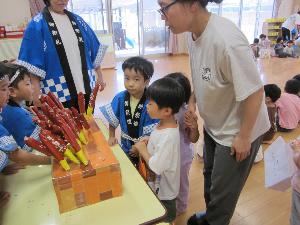 縁日遊びでチョコバナナを買っている様子