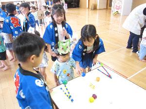 2歳児と5歳児が射的をしている様子