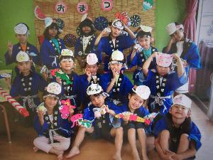 すみれ組の子たちがおみこしの前で集合写真を撮っているところ