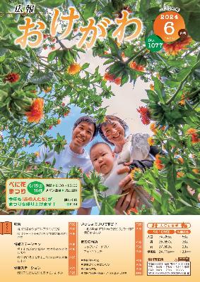 広報おけがわ6月号の表紙画像。べに花畑に咲くべに花の隙間から顔をのぞかせる夫婦と赤ちゃんの家族写真