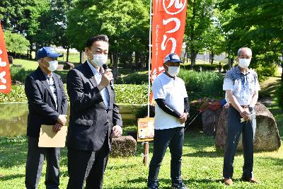 第4回初めての魚釣り体験の画像。イベントを前に城山公園の大池を背景にしてあいさつをする小野桶川市長。