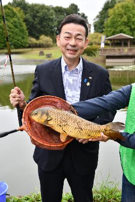 第4回初めての魚釣り体験の画像。第1回大会（令和元年）で40センチを超える鯉を釣り上げた小野桶川市長の様子が写っている。