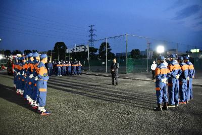 埼玉県操法大会に出場するため訓練を重ねる桶川市消防団の様子の画像。各分団から選抜された8人の団員を前にあいさつに立ち小野桶川市長が写っている。