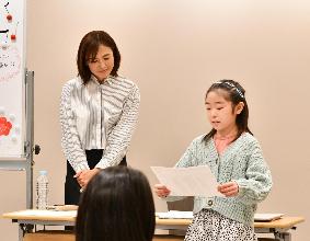 参加した子どもが原稿を読み上げるアナウンサー体験をしている写真