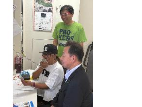 OK桶川ラジオの二人と桶川市長が施設内放送を行っている写真