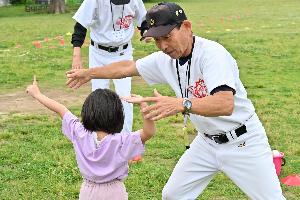 子どもにボールの投げ方を教えるかじ川さんの写真