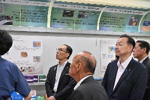 三共理化学株式会社で工場視察と自社ブランド製品「FUJISTAR」の製造に関する話を聞いている県知事、県議、桶川市長の写真