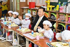 加納小学校の生徒と桶川市長が給食を食べている写真