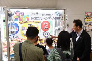クレーンゲームに参加している親子と桶川市長の写真