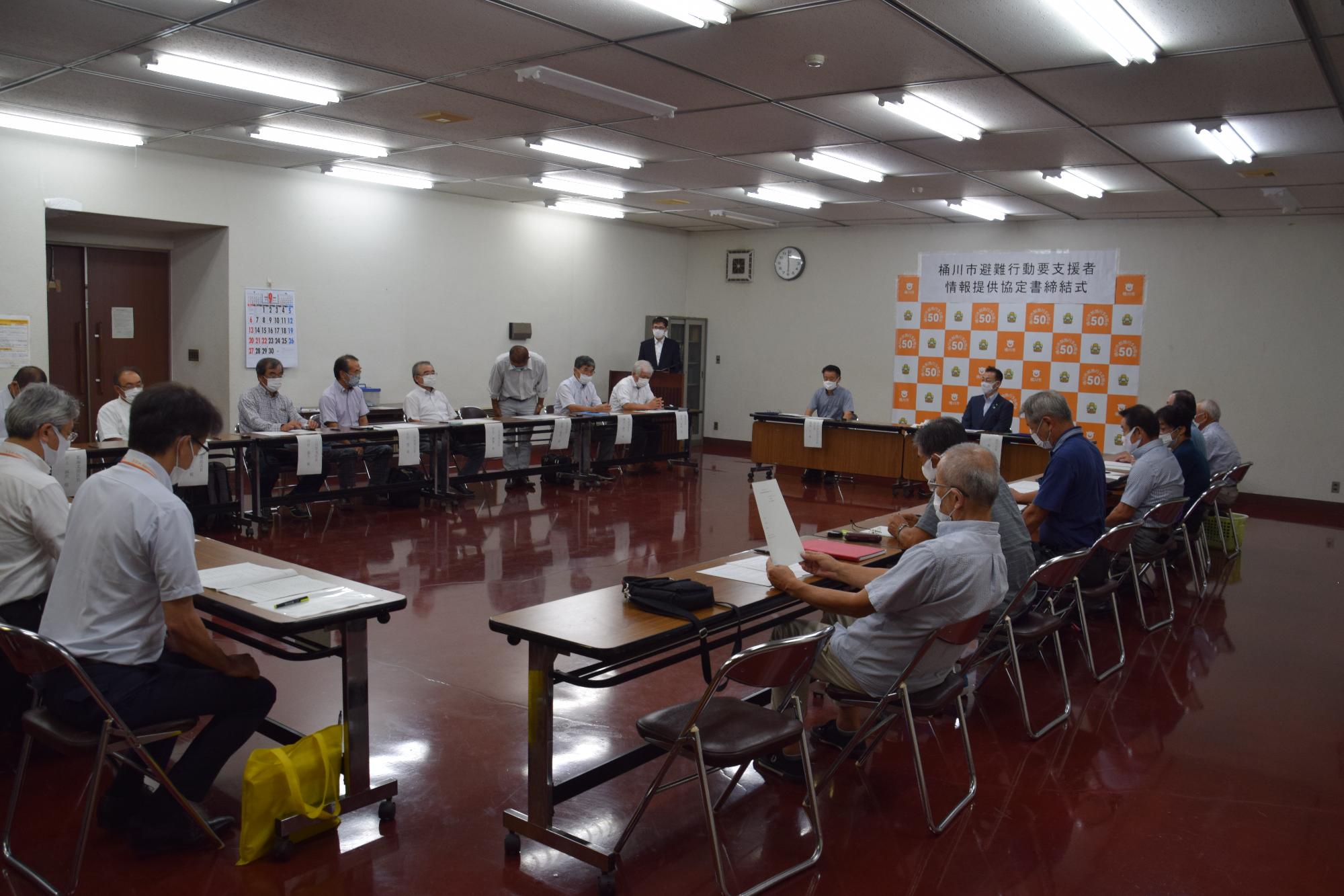 桶川市避難行動要支援者情報提供協定書締結式で長机をロの字に配置し出席者が座っている様子