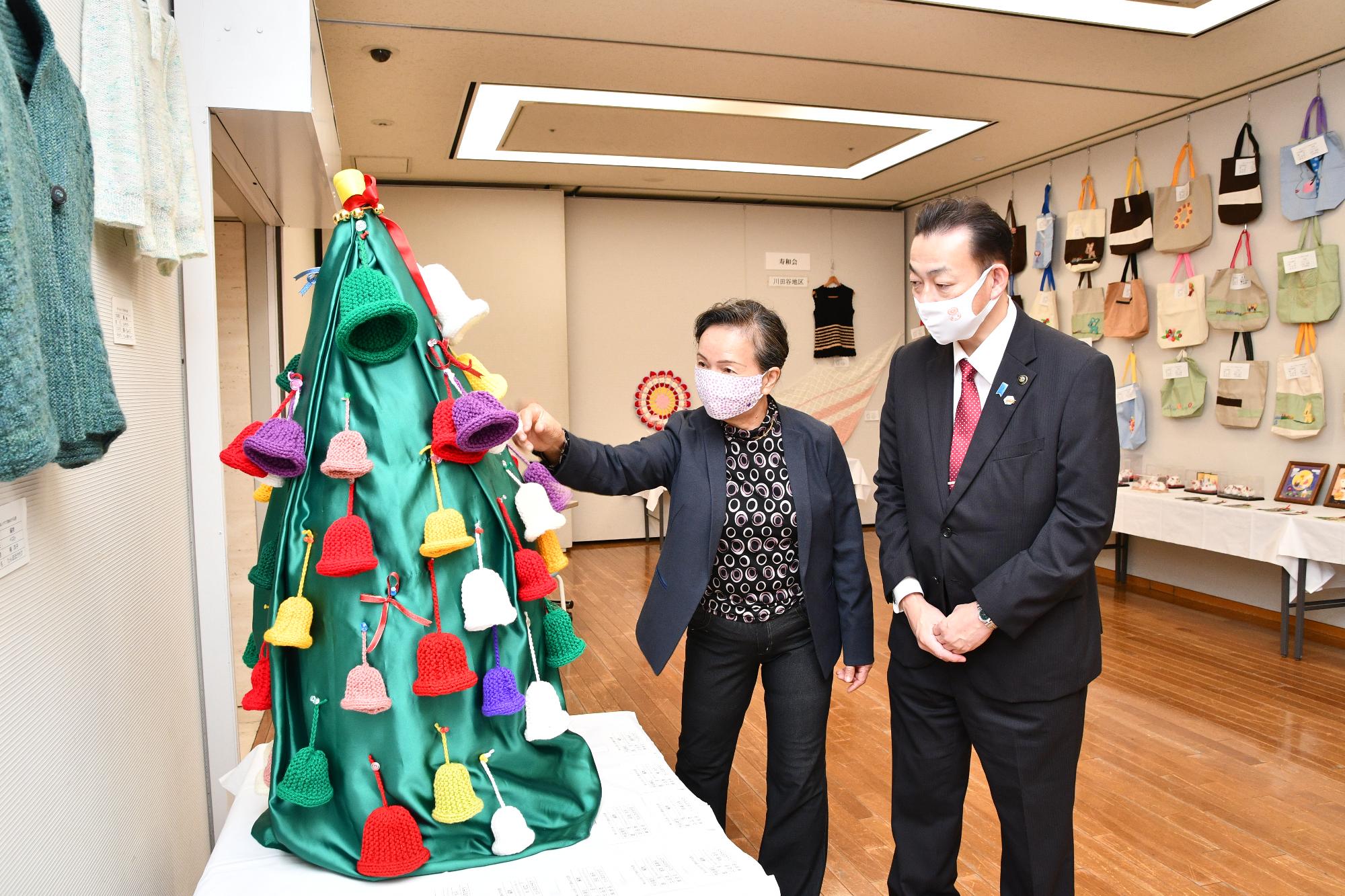 市民ホールで開催された「ふれあいクラブフェスティバル趣味の作品展」で市民と市長が作品を見ている様子