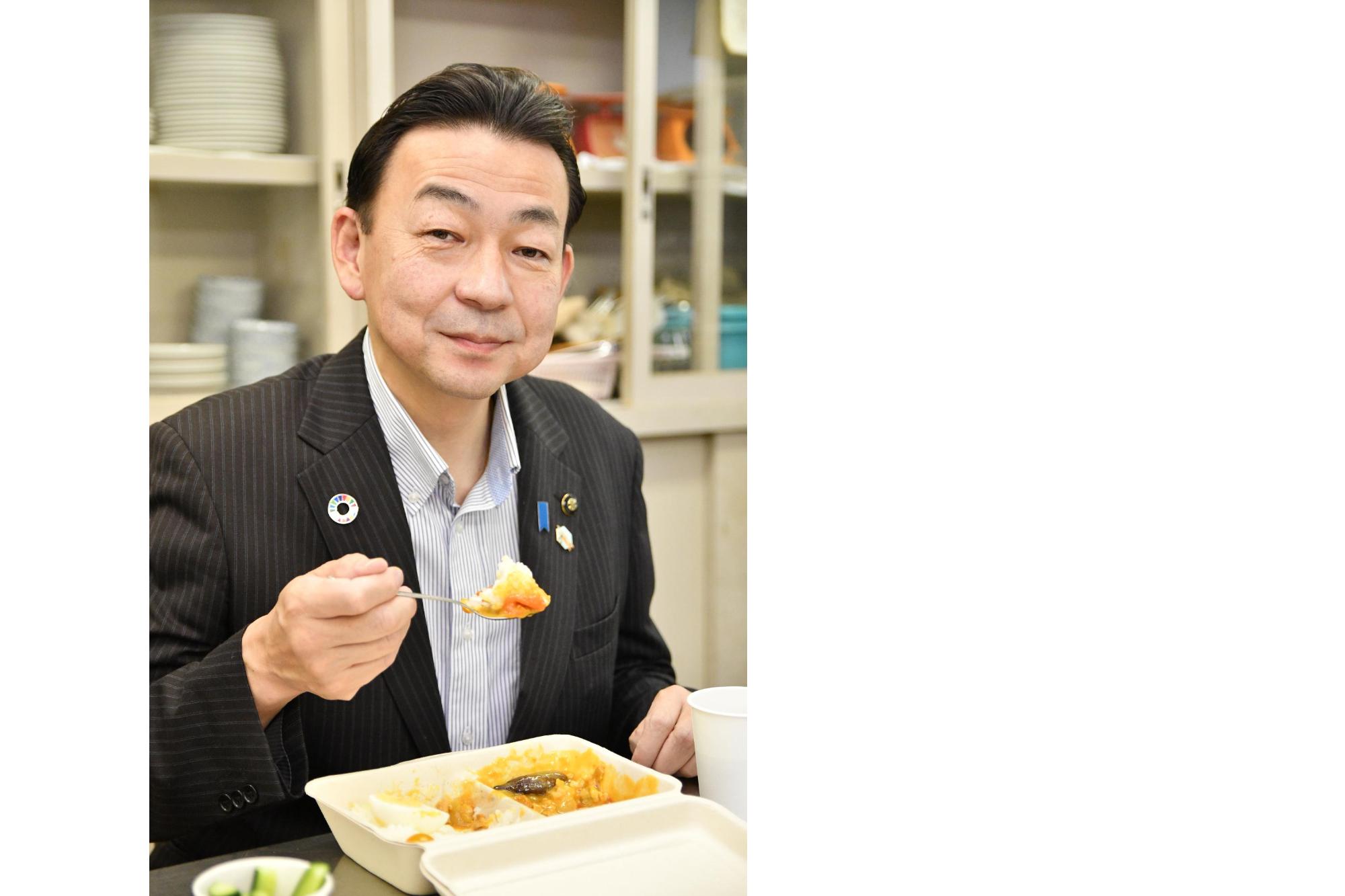 小野克典市長が、子ども食堂でテイクアウトした夏野菜カレーを食べている様子。