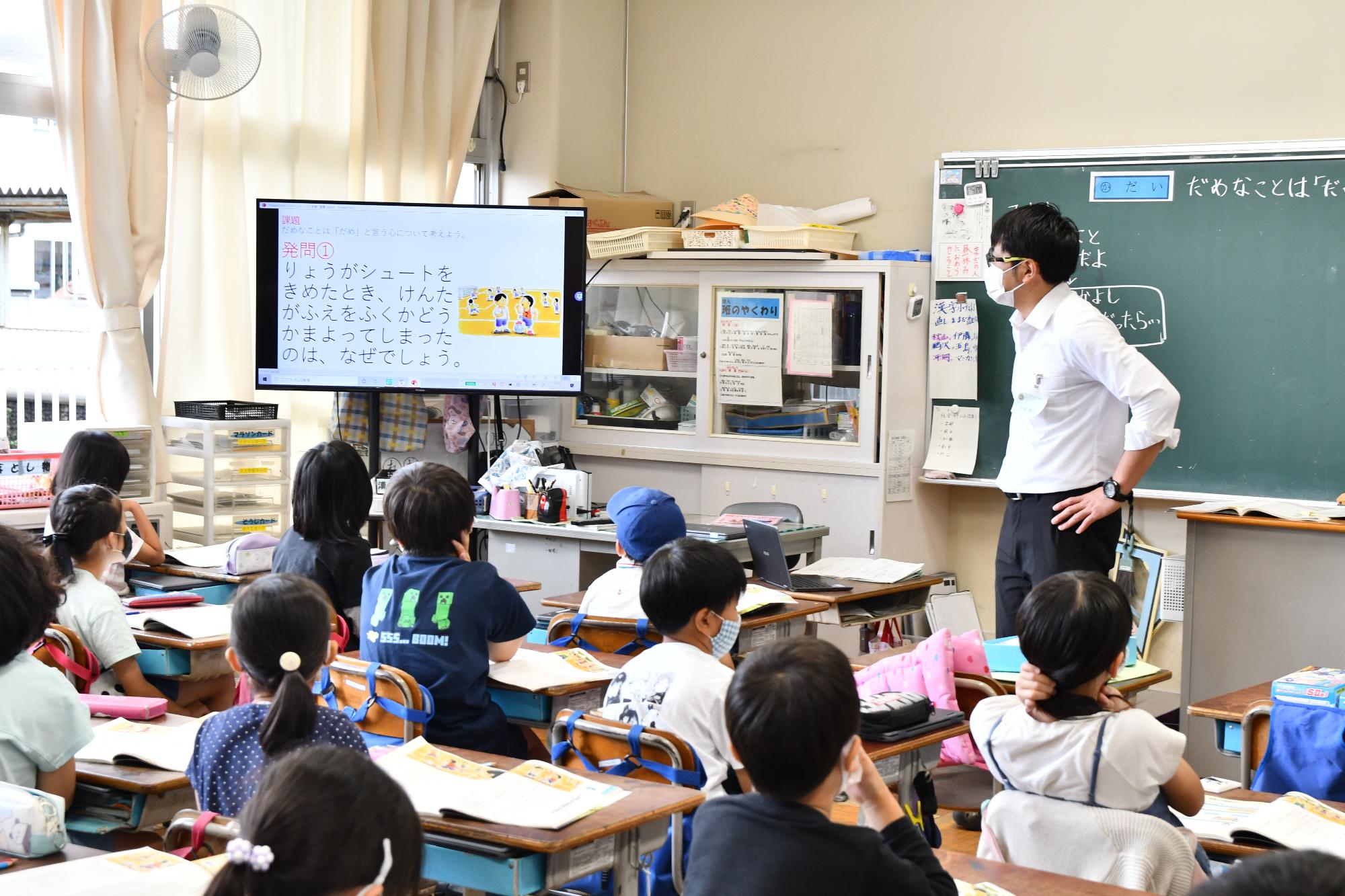 桶川小学校で大型ディスプレイを使用した授業をしている先生と児童の様子