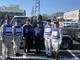 石川県輪島市と志賀町へ給水タンク車を派遣する桶川水道企業団職員と並んで撮影する小野市長
