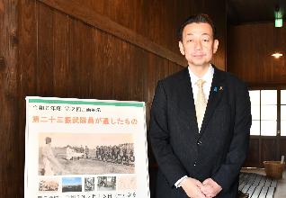 桶川飛行学校平和祈念館企画展のボードの横で桶川市長が立っている写真
