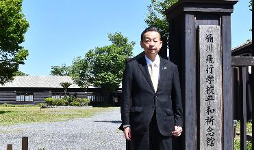 桶川飛行学校平和祈念館の入口で立っている桶川市長の写真