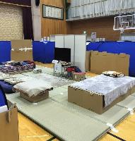 市内小学校体育館で行われた避難所開設の様子。簡易の床やベッド、壁などが建てられている。