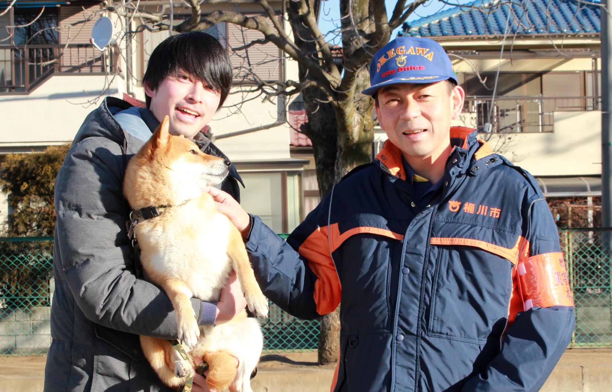 ペット同伴避難訓練の時の写真で、左側に犬を抱きかかえた人がいて、その右側に市長がいる