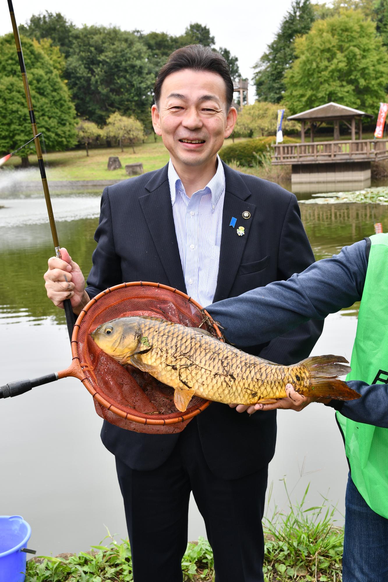 市長が釣ったコイと写った写真