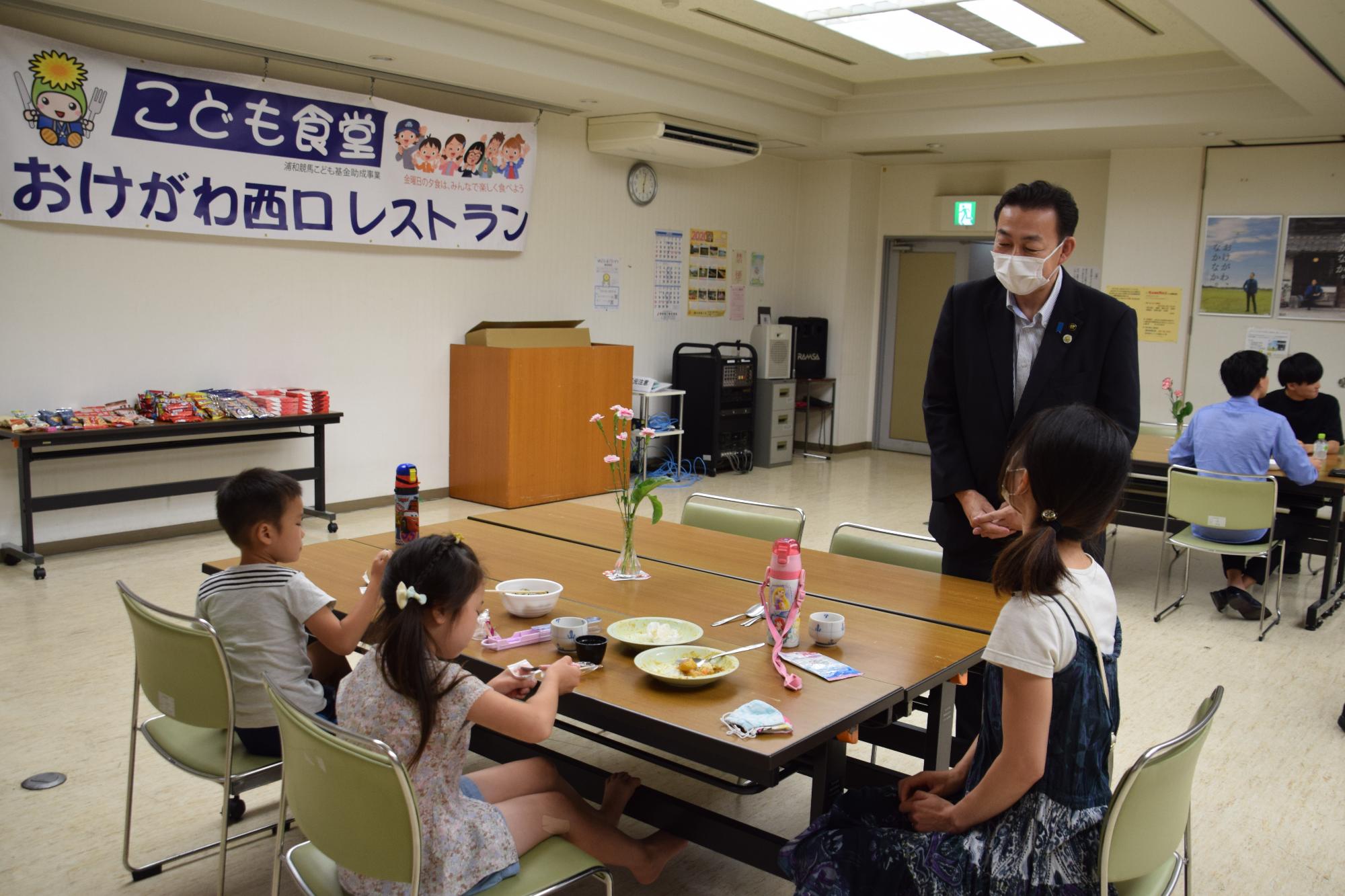 子ども食堂「おけがわ西口レストラン」に来てくれた親子に市長が話しかけている様子