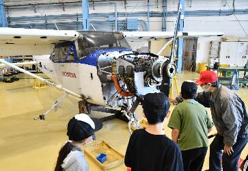 飛行機の内部を見ながら、飛行機が飛ぶ仕組みや機体の構造などを学ぶ子どもたち