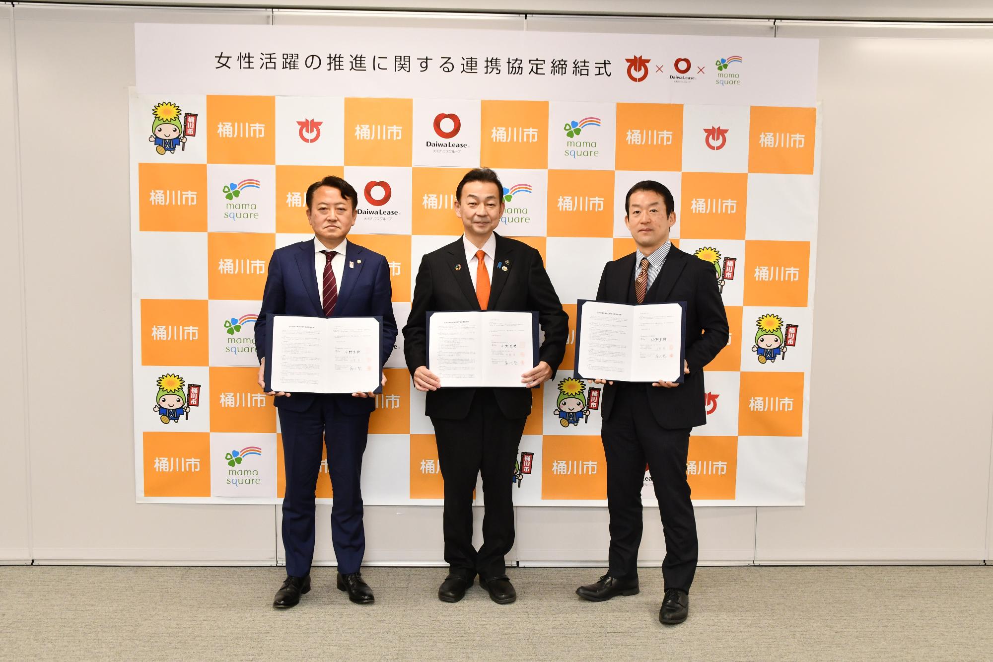 写真 左：古賀 章 さいたま支店 支店長、中央：小野 克典 桶川市長、右：藤代 聡 代表取締役